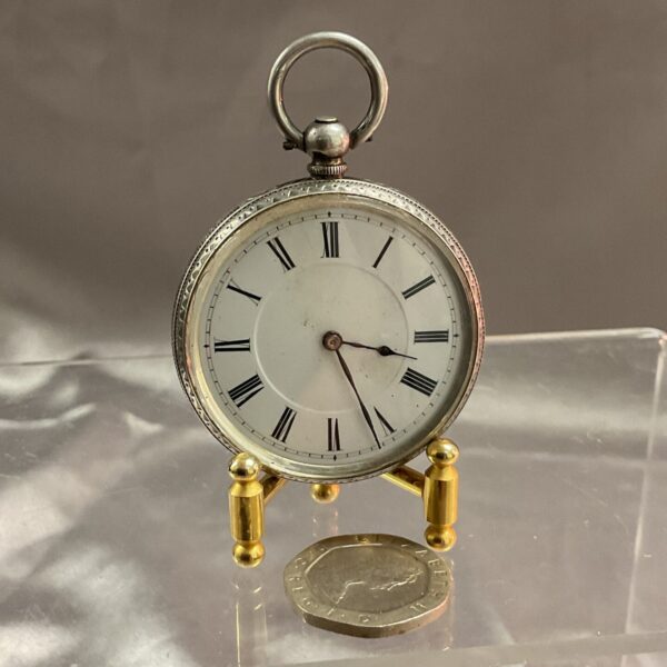 Antique silver pocket watch with white enamel dial.
