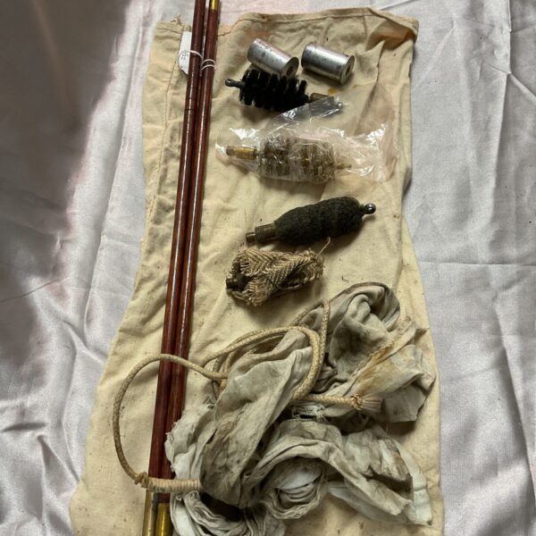 Vintage shotgun cleaning kit with brass rod and brushes.