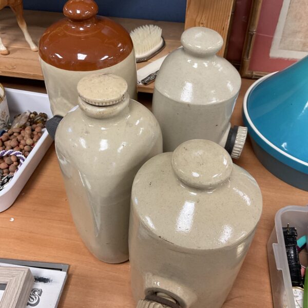 Group of four antique stoneware hot water bottles, vintage bed warmers.