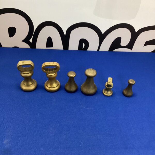 Vintage brass weights displayed as a collectible lot.