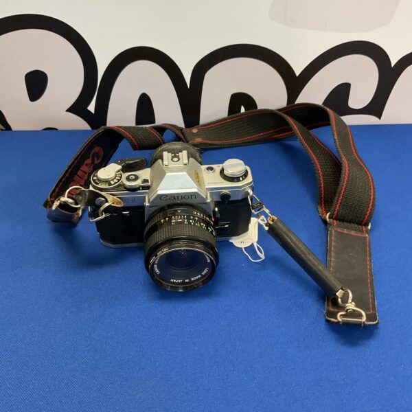 Front view of a vintage Canon AE-1 film camera with strap.
