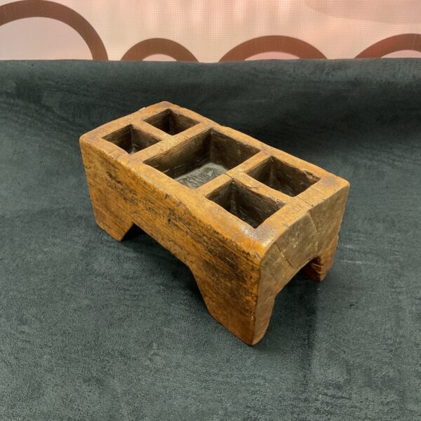 Antique wooden spice box with multiple compartments, front view.