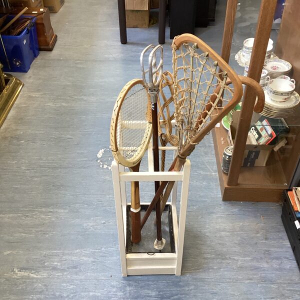 Vintage wooden umbrella stand displaying a shooting stick.
