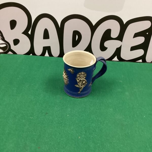 Close-up of a Martin Homer handmade floral mug with blue glaze.