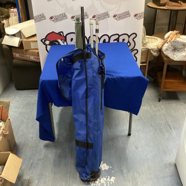 Blue fishing bag holding bank sticks and landing net handle.