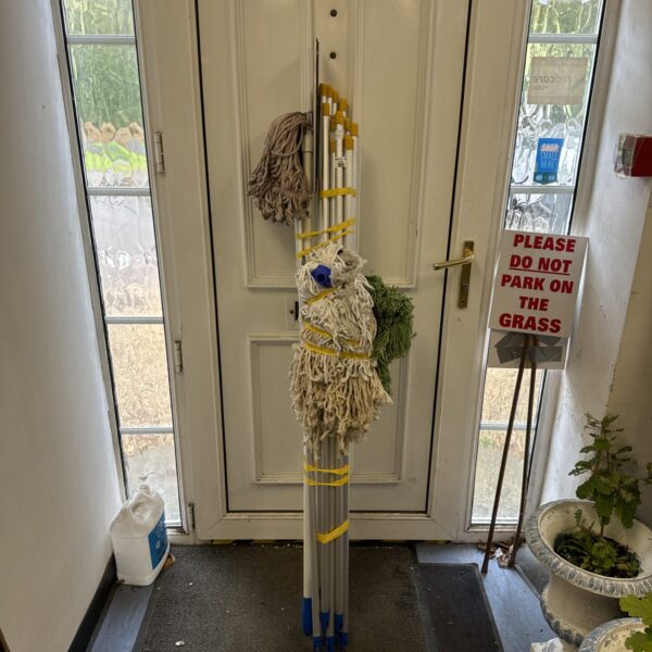 Lot of used mop heads and poles for floor cleaning.