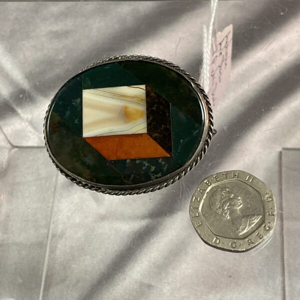 Antique Art Deco pietra dura brooch with geometric hardstone inlay.