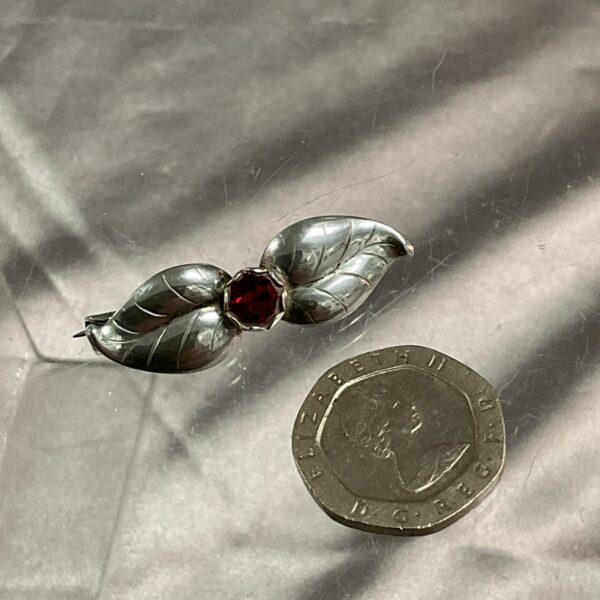 Vintage silver leaf brooch by H S Herman with red stone.