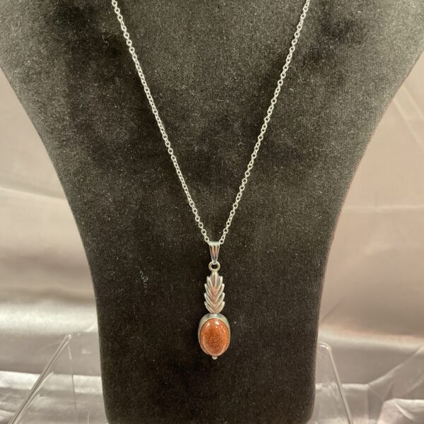 Vibrant gold stone pendant on a silver chain necklace.