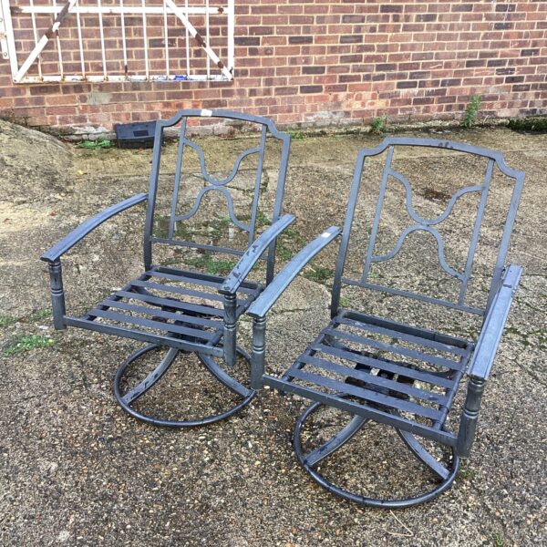 Pair of vintage metal garden chairs in a garden setting.