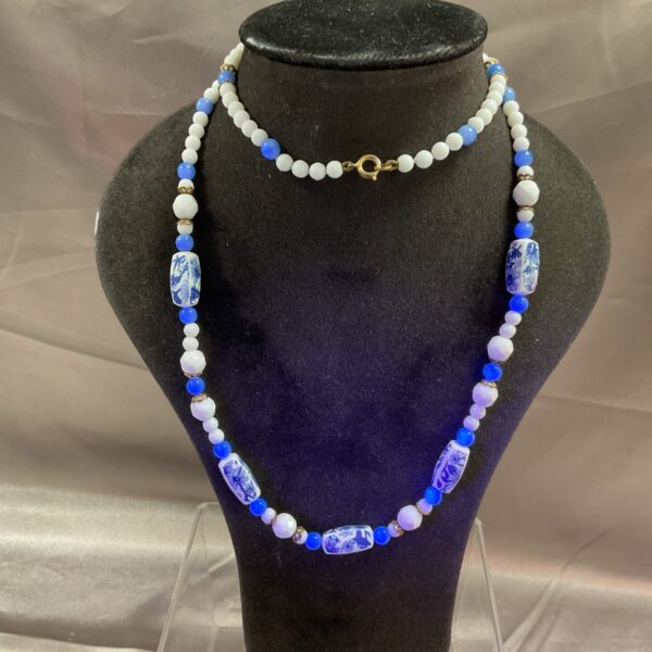 Close-up of a blue and white floral bead necklace on a display bust.