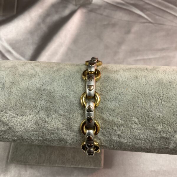 Close-up of Rotary heart link bracelet with gold and silver tones.