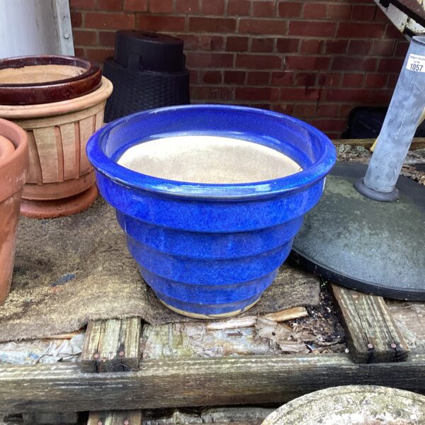 Vibrant blue glazed garden pot for outdoor plants.