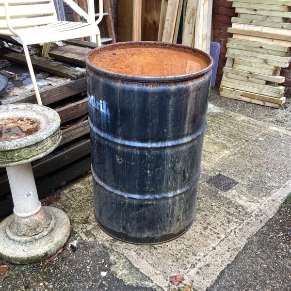 Weathered metal oil drum showing industrial wear and tear.