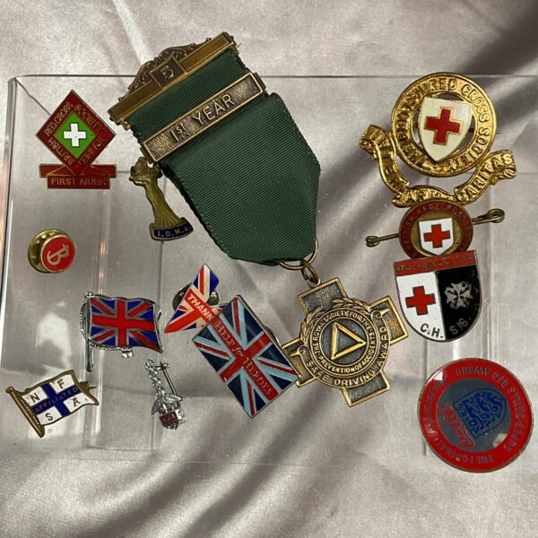 Vintage Red Cross badge and safe driving medal collection.
