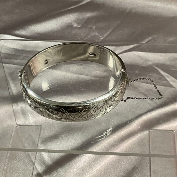 Vintage sterling silver hinged bracelet with embossed detailing.