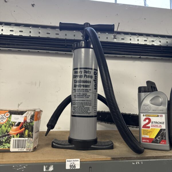 Close-up of a vintage stirrup pump with metal construction.