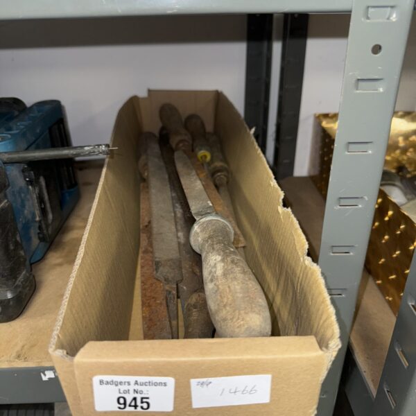 A lot of assorted metal files in a workshop setting.