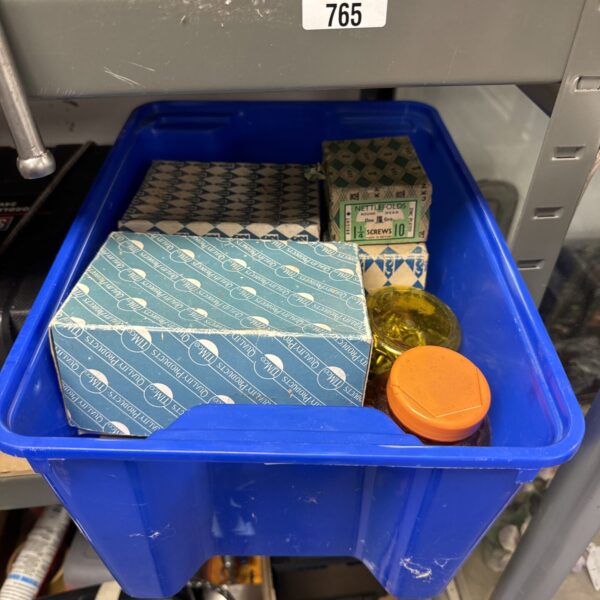 Assorted metal screws in a plastic container, hardware lot.