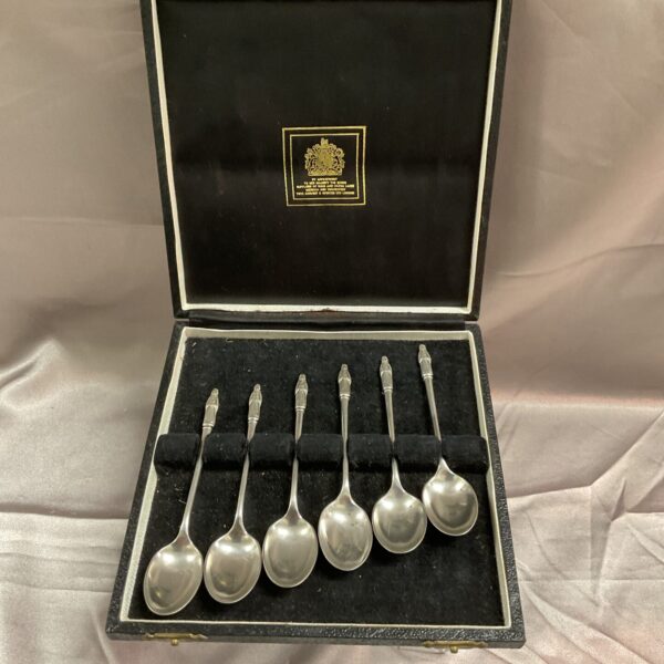 Antique silver apostle spoons in a velvet-lined box.