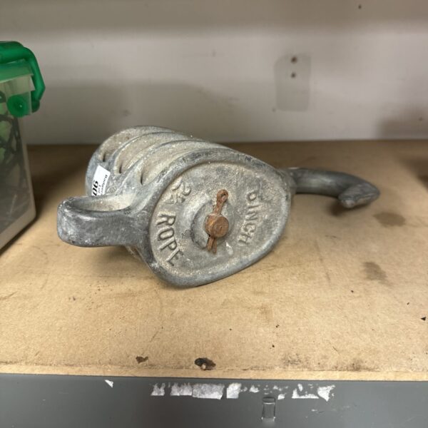 Vintage metal rope pulley for farm or industrial use.