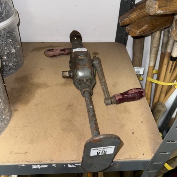 Vintage drill brace with curved handle, antique woodworking tool.