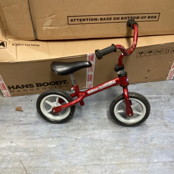 Red Chicco balance bike for toddlers learning to ride.