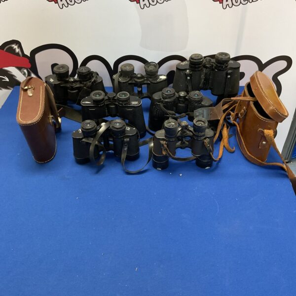 Vintage binoculars collection with carry cases displayed.