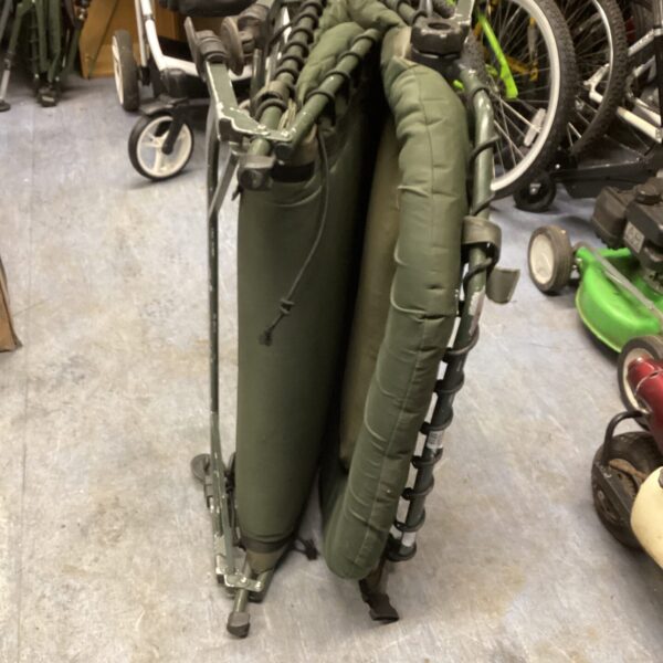 Green Prestige folding camp bed, ready for outdoor use.