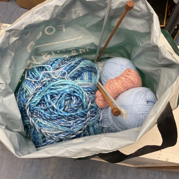 Colourful knitting yarn lot with needles for crafting projects.