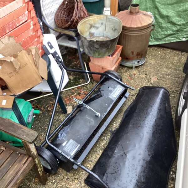 Used Cobra lawn sweeper in a garden setting.