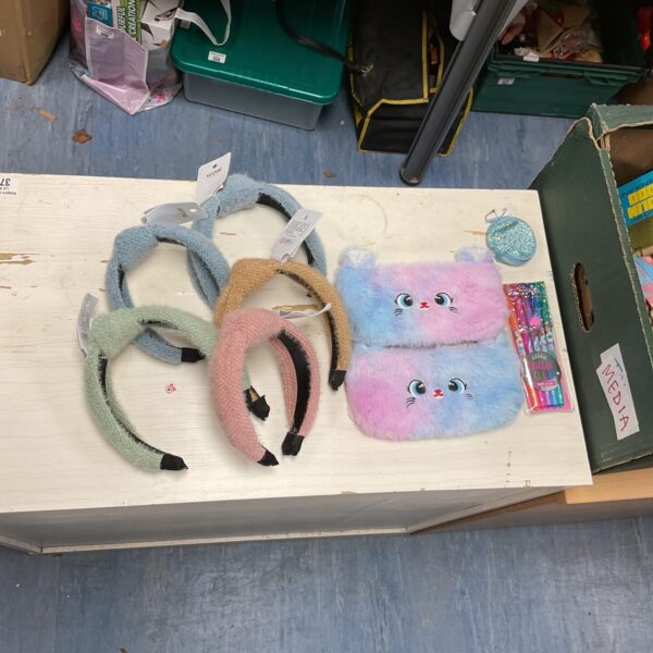 Mixed lot of colourful hair accessories and stationery items.