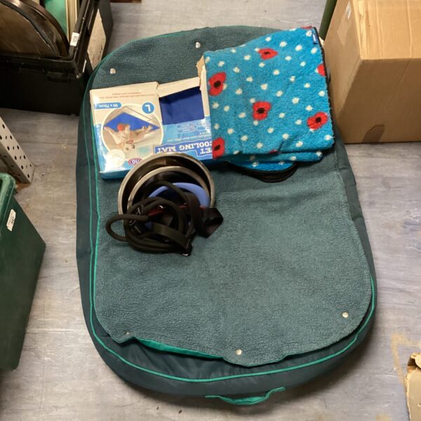Circular dog bed with blankets and pet accessories.
