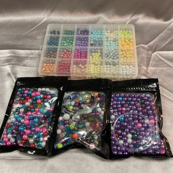 Colourful assortment of glass jewellery making beads in a clear bag.