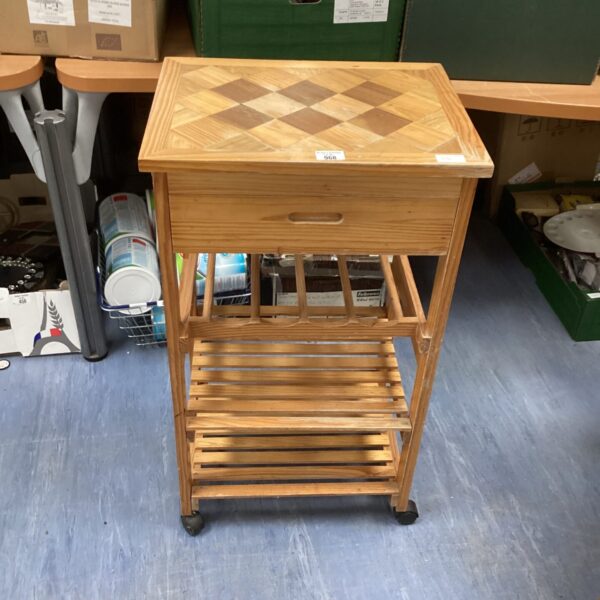 Small pine kitchen trolley with wine rack for storage.
