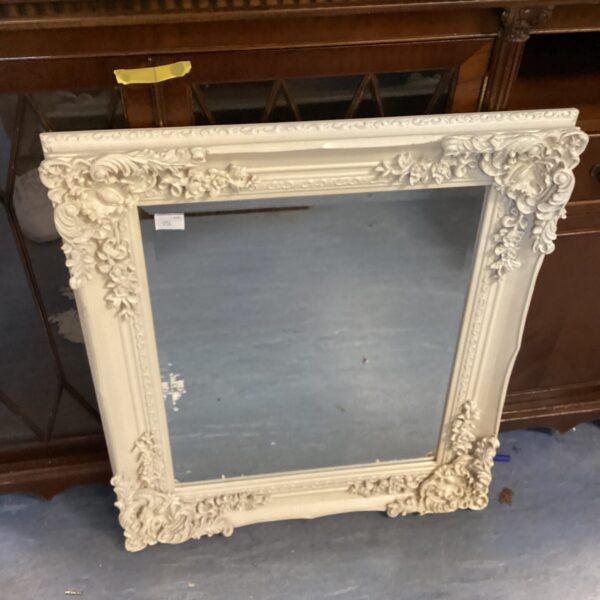Ornate French style bedroom mirror with cream frame.