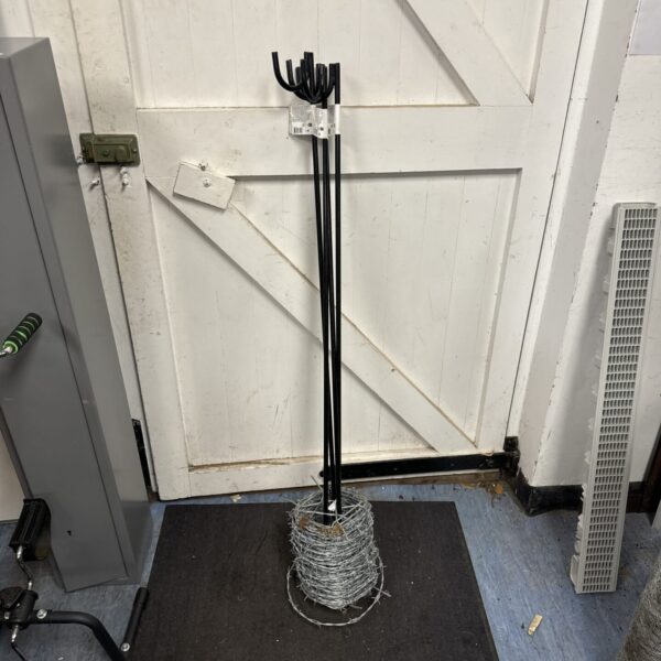 Bundle of barbed wire and metal fencing posts for garden use.
