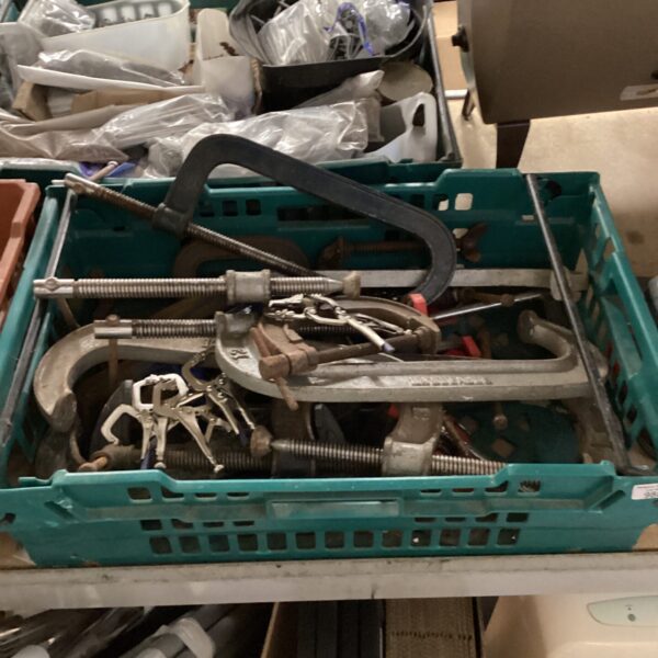 Tray of vintage metal G clamps for woodworking projects.