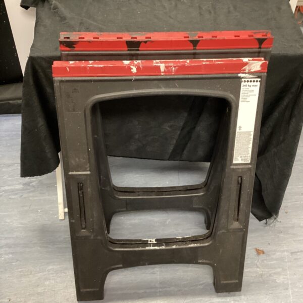 Pair of metal folding trestles for workshop or event use.