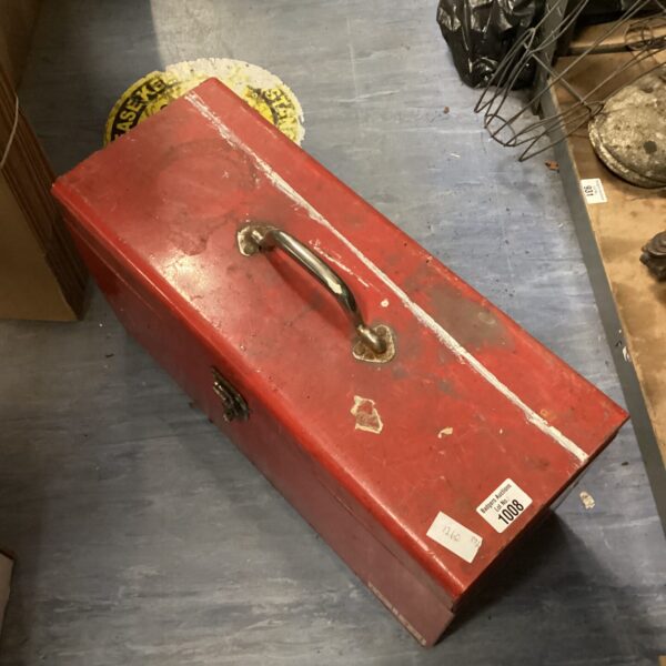 Vintage red metal toolbox with carrying handle, ideal for tool storage.