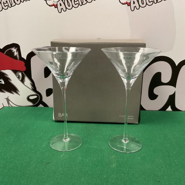 Two elegant LSA hand blown cocktail glasses on a dark surface.