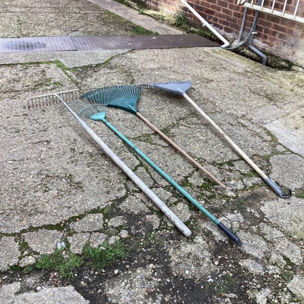 Lot of four vintage garden rakes for yard work.