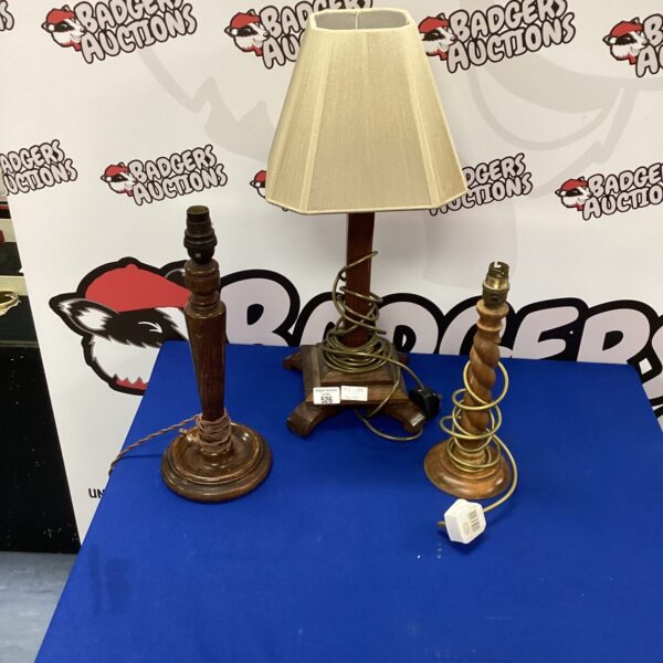 Three vintage wooden table lamps with fabric shades.