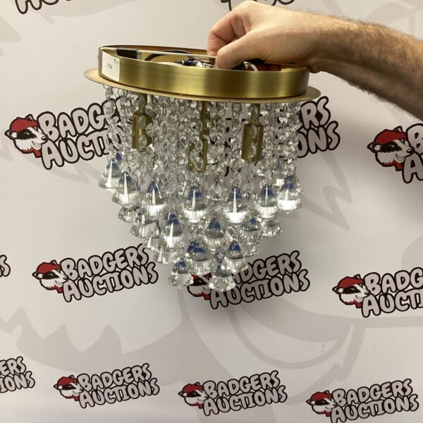 Vintage brass ceiling light with cascading crystal droplets.
