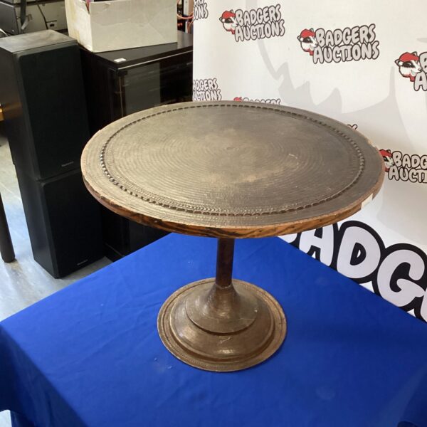Vintage hammered copper occasional table with a warm patina.
