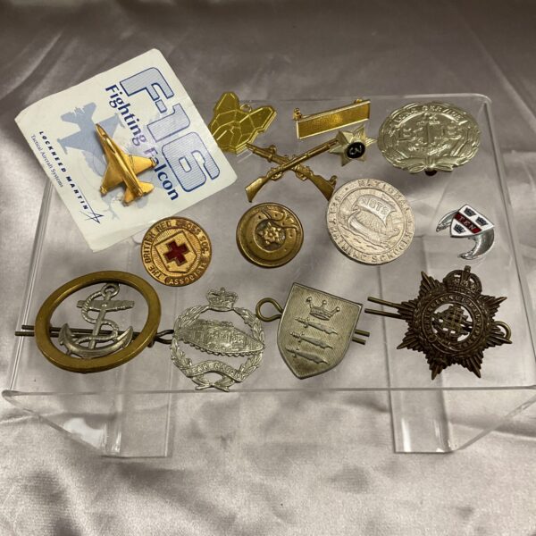 Assorted vintage military badges on a dark background.