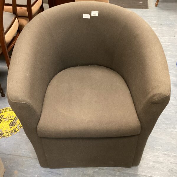 Side view of a grey tub chair with a rounded form.