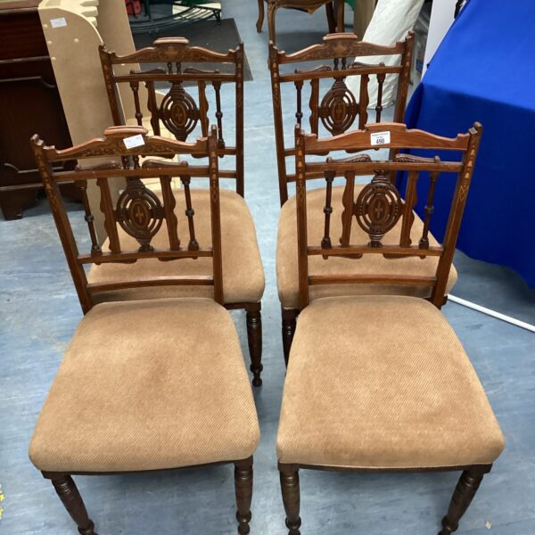 Set of four vintage inlaid dining chairs with detailed backs.