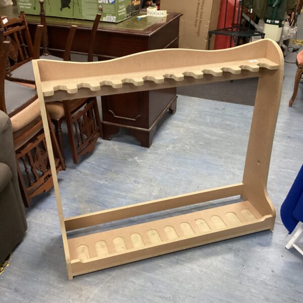 Wall-mounted MDF gun rack displaying multiple rifle slots.