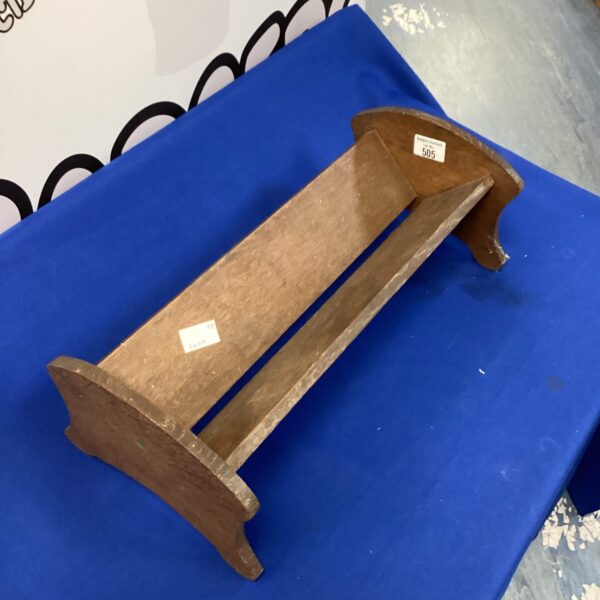 Vintage wooden book rack for displaying books and collectibles.